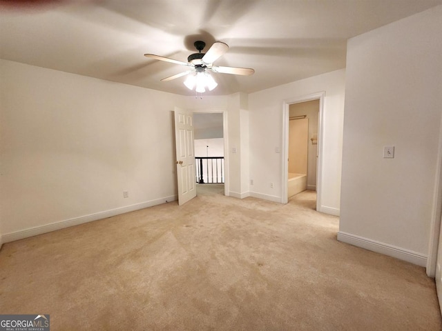 unfurnished bedroom with light carpet, ensuite bathroom, and baseboards