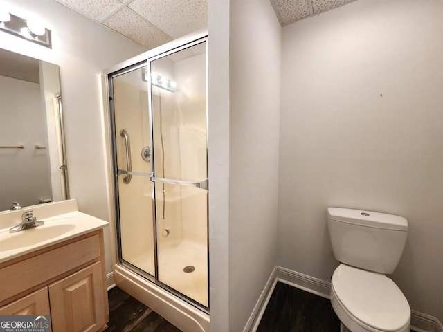 full bathroom with a paneled ceiling, a shower stall, toilet, and vanity