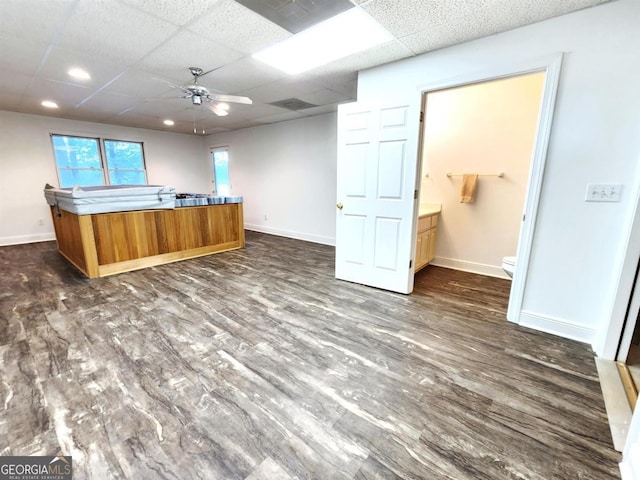 kitchen featuring dark wood-style floors, baseboards, and a drop ceiling