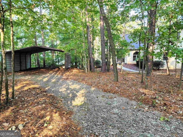 view of yard with gravel driveway and a carport