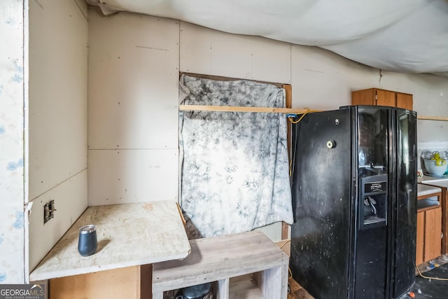 kitchen with black refrigerator with ice dispenser