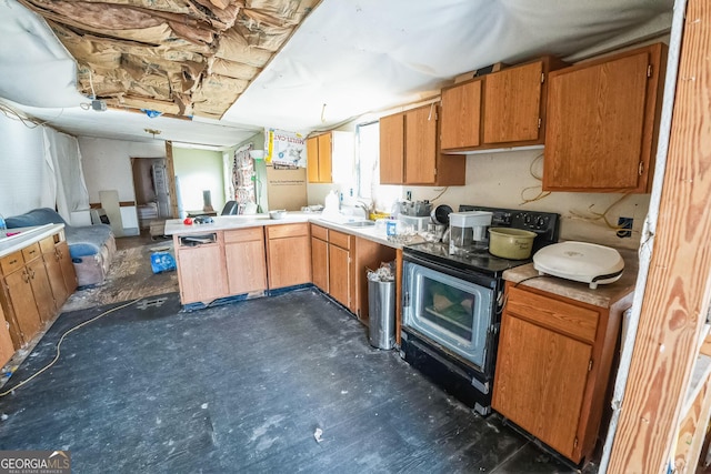 kitchen featuring electric stove, brown cabinets, light countertops, open floor plan, and a peninsula