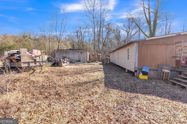 view of yard featuring a storage shed and an outdoor structure