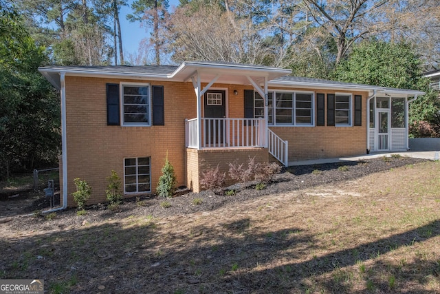 view of front facade with brick siding and a sunroom