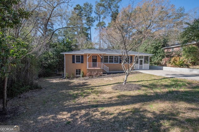 single story home with a front lawn, concrete driveway, and brick siding