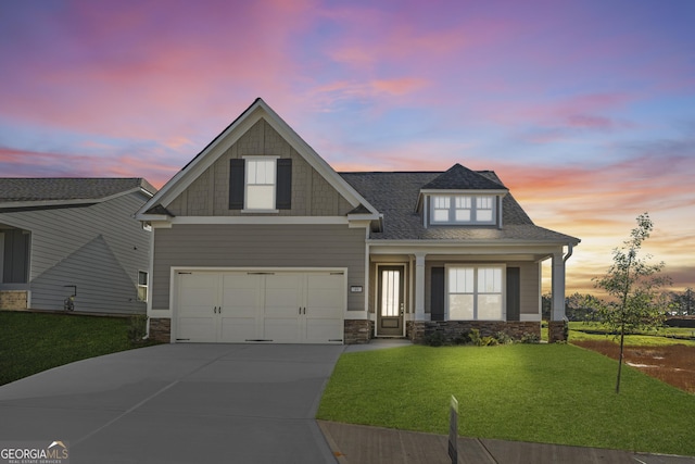 craftsman house featuring a garage, a yard, roof with shingles, and driveway