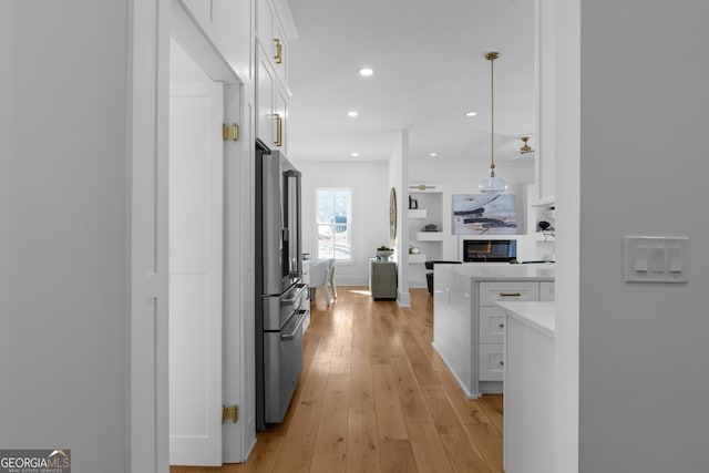 corridor featuring light wood-style flooring and recessed lighting