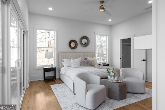 bedroom with light wood-type flooring, multiple windows, and recessed lighting