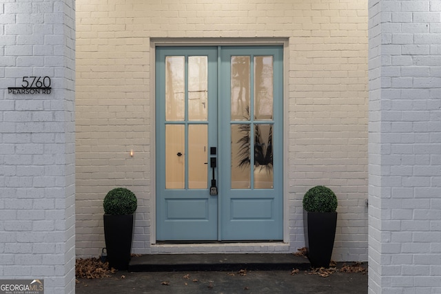 doorway to property featuring french doors and brick siding