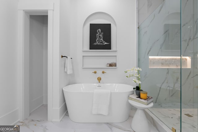 full bathroom featuring marble finish floor, a freestanding bath, and a marble finish shower