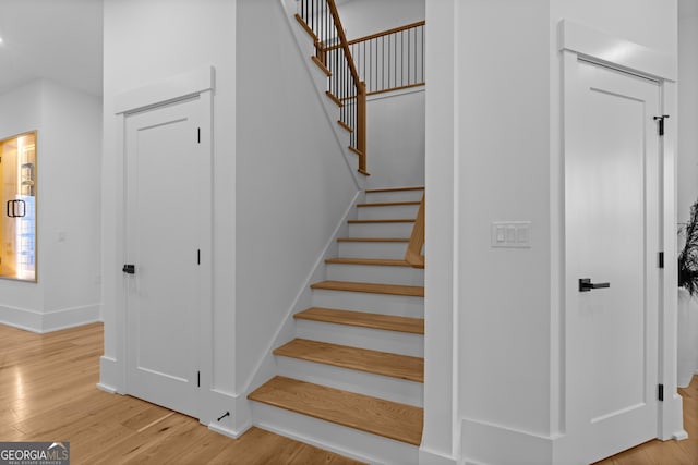 stairway with baseboards and wood finished floors