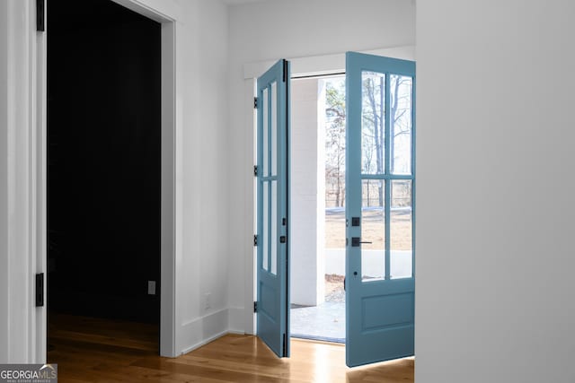 entryway with baseboards and light wood finished floors