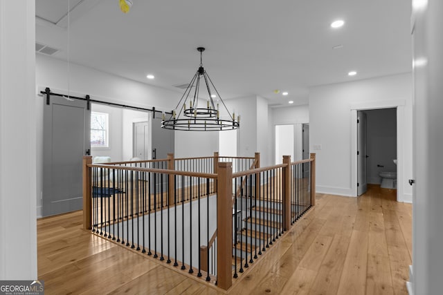 corridor with light wood-type flooring, visible vents, and recessed lighting