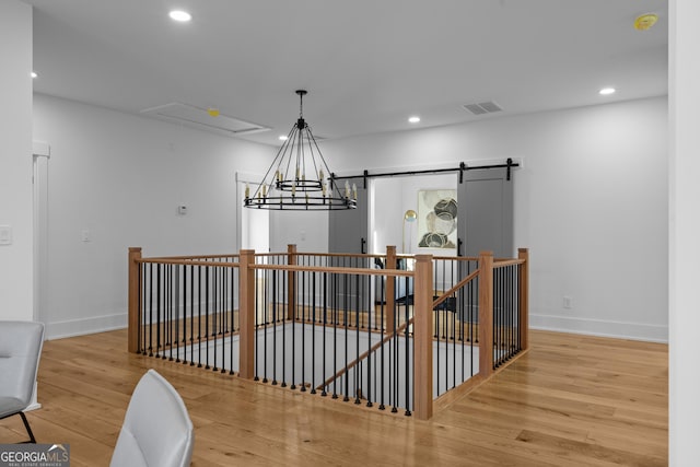 dining room with a barn door, baseboards, visible vents, wood finished floors, and recessed lighting