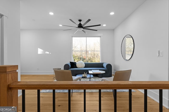 living room featuring a ceiling fan, recessed lighting, baseboards, and wood finished floors