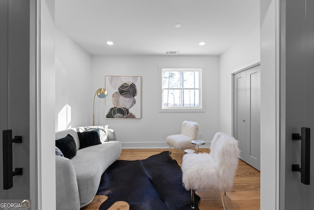 living area with visible vents, wood finished floors, and recessed lighting