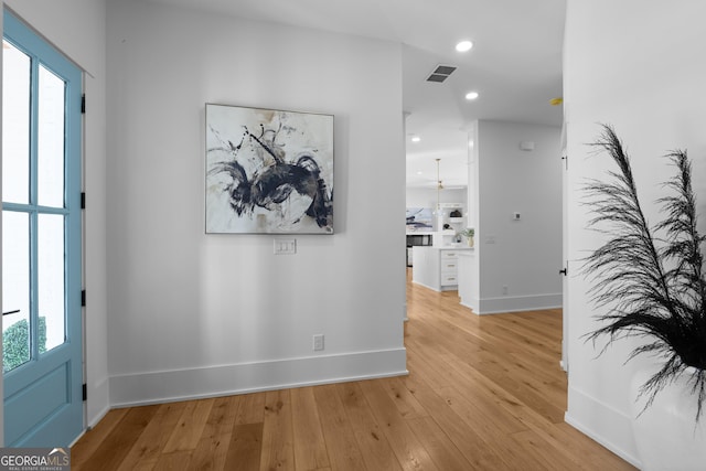 hallway with light wood-style floors, recessed lighting, visible vents, and baseboards