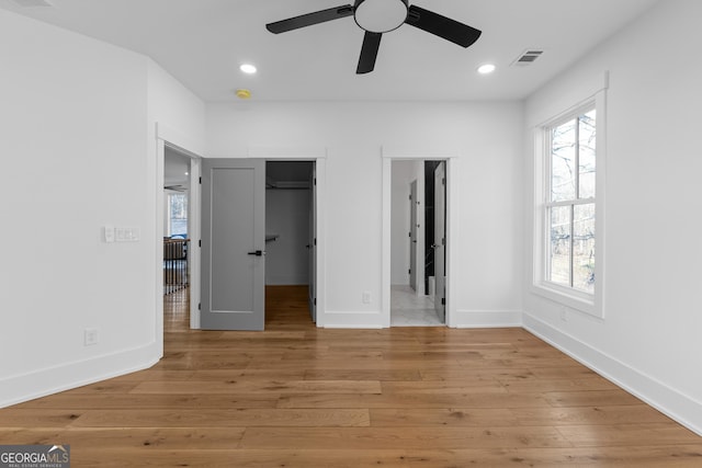 unfurnished bedroom featuring recessed lighting, visible vents, baseboards, a spacious closet, and light wood-type flooring