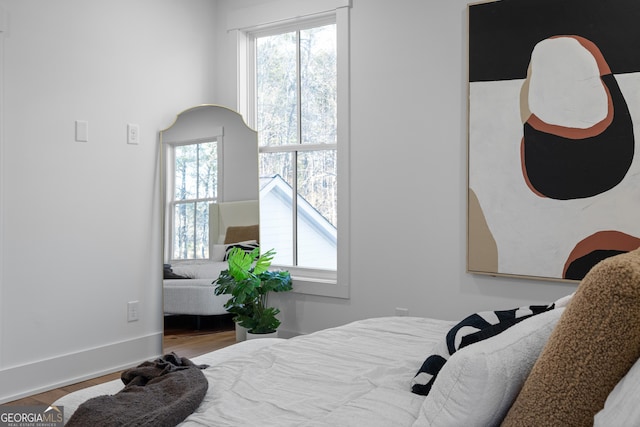 bedroom with baseboards and wood finished floors