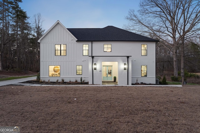 modern farmhouse style home featuring roof with shingles and board and batten siding