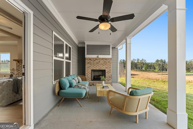 view of patio / terrace featuring an outdoor living space with a fireplace and a ceiling fan