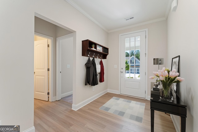 interior space with ornamental molding, light wood-type flooring, visible vents, and baseboards