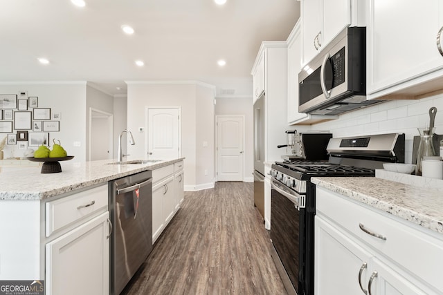 kitchen featuring appliances with stainless steel finishes, a sink, white cabinets, and decorative backsplash