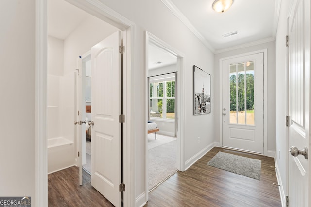 foyer featuring baseboards, visible vents, dark wood-type flooring, and ornamental molding