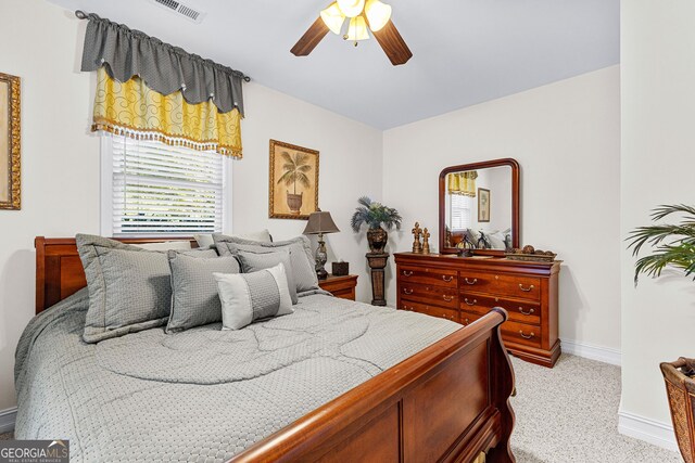 bedroom featuring baseboards, ceiling fan, visible vents, and light colored carpet