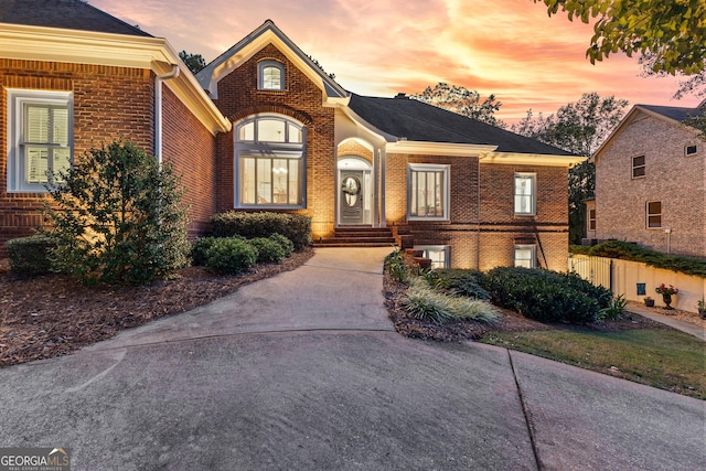 view of front of property with brick siding and fence