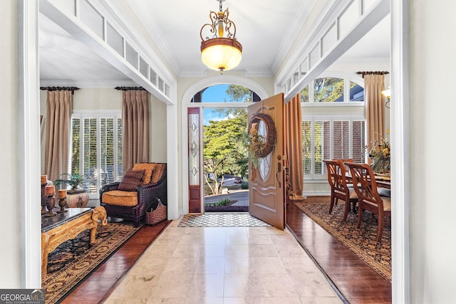 tiled foyer entrance featuring crown molding