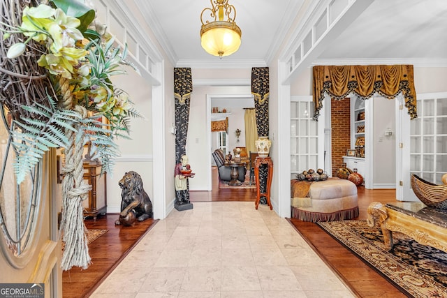 entrance foyer with baseboards, ornamental molding, and wood finished floors