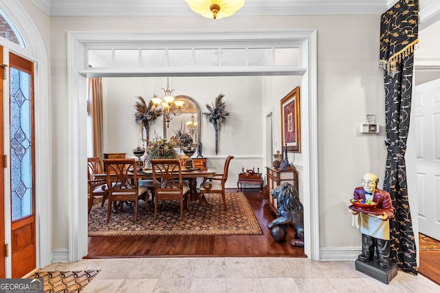 tiled dining space featuring an inviting chandelier, baseboards, and crown molding