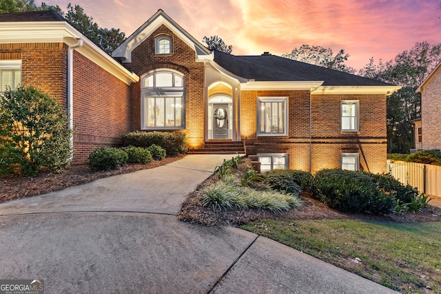 view of front of house with brick siding and fence