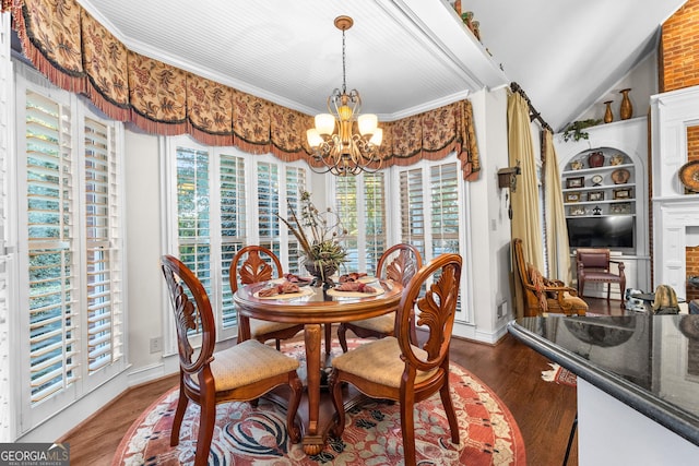 dining room with lofted ceiling, an inviting chandelier, ornamental molding, wood finished floors, and baseboards