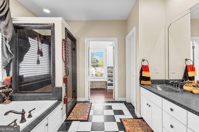 full bath featuring a garden tub, a shower stall, baseboards, and vanity