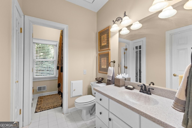 bathroom featuring visible vents, toilet, vanity, baseboards, and tile patterned floors