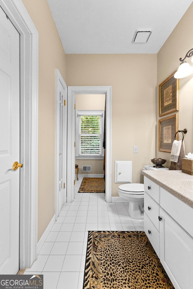 bathroom featuring toilet, vanity, visible vents, and tile patterned floors