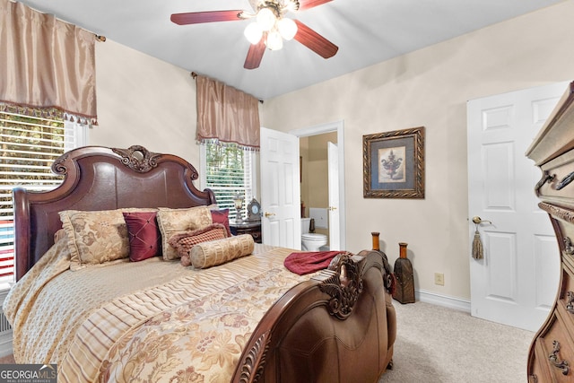 carpeted bedroom with ceiling fan, baseboards, and ensuite bathroom