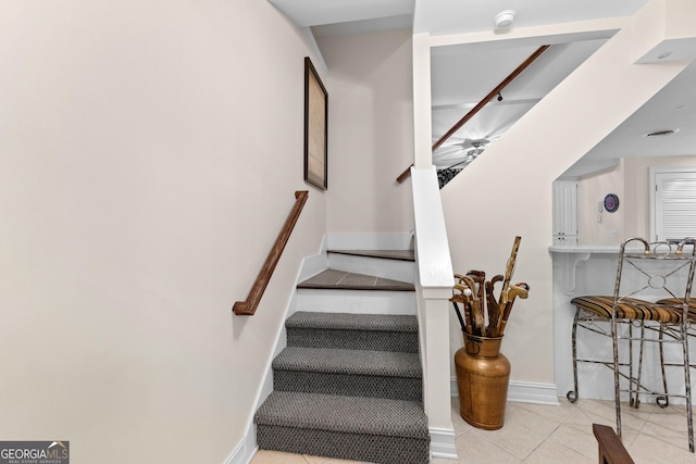 stairs featuring tile patterned flooring and baseboards