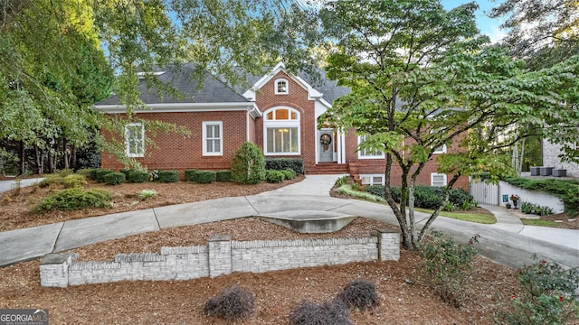 view of front of house featuring a shingled roof and brick siding