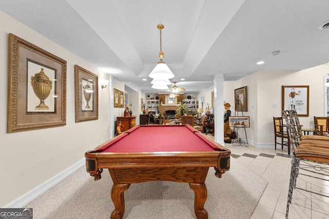 rec room featuring ornate columns, a tray ceiling, a fireplace, and recessed lighting