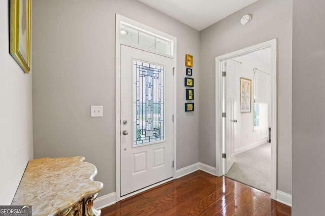 entryway featuring dark wood-type flooring, plenty of natural light, and baseboards