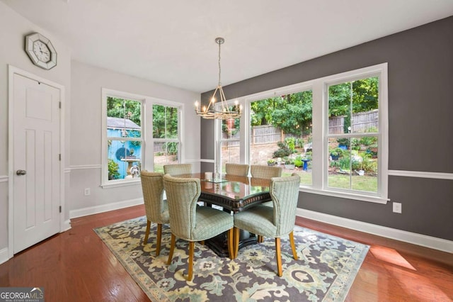 dining area featuring wood finished floors, a wealth of natural light, and an inviting chandelier