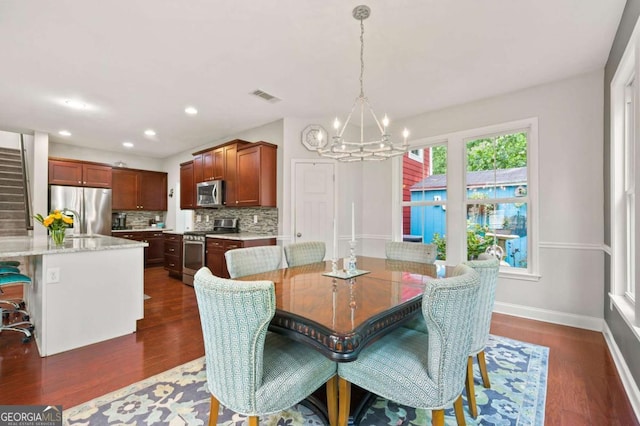 dining space with an inviting chandelier, baseboards, visible vents, and dark wood finished floors