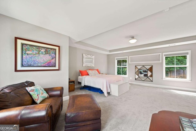 bedroom featuring carpet, a tray ceiling, and baseboards