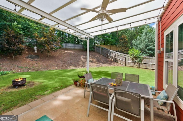 view of patio featuring outdoor dining area, a ceiling fan, an outdoor fire pit, a pergola, and a fenced backyard