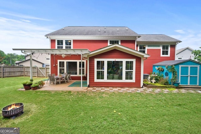 rear view of house featuring an outdoor fire pit, a patio, an outbuilding, a storage unit, and fence