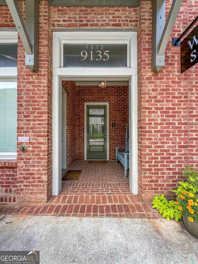 property entrance featuring brick siding