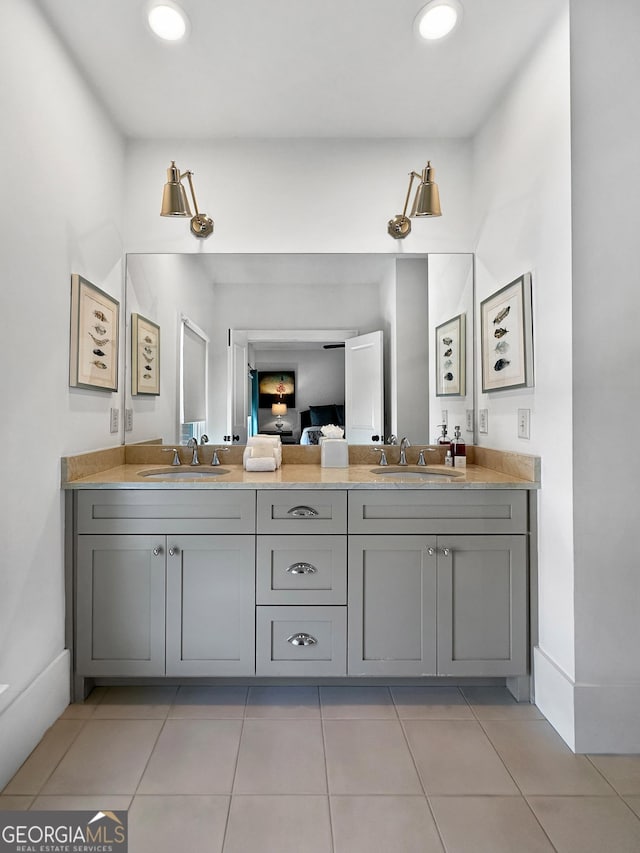 ensuite bathroom featuring tile patterned floors, a sink, recessed lighting, and double vanity